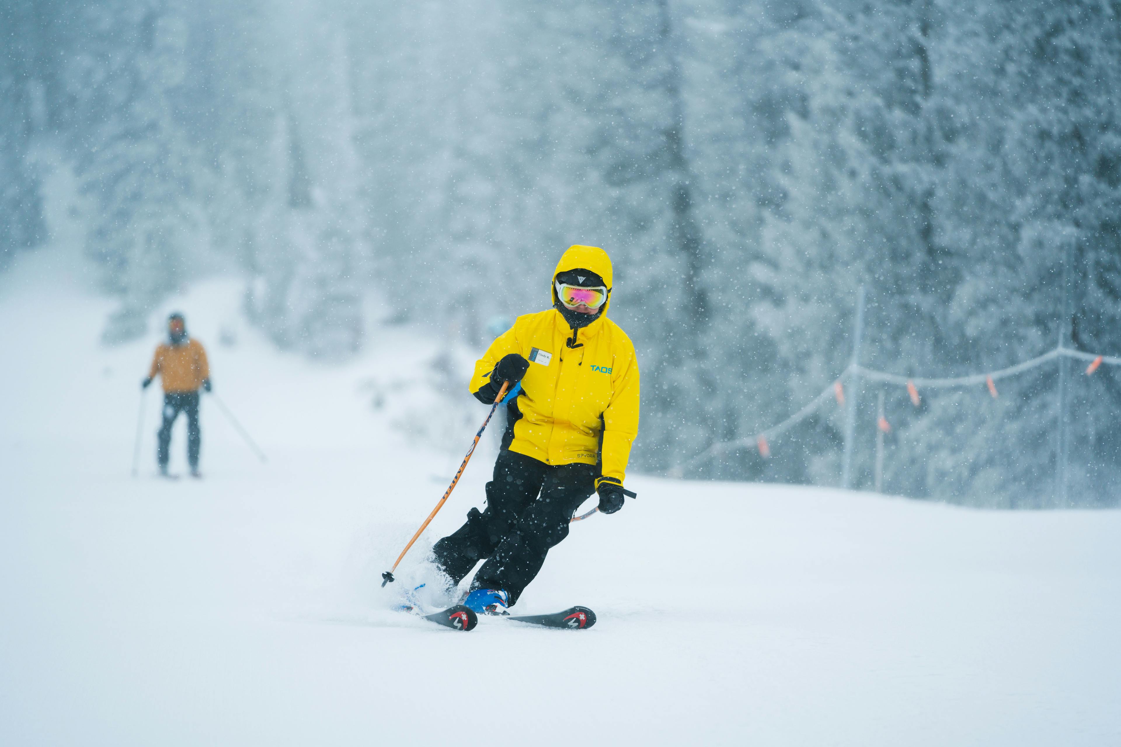 Snowsports instructor leads the way down on a snowy day at Taos Ski Valley