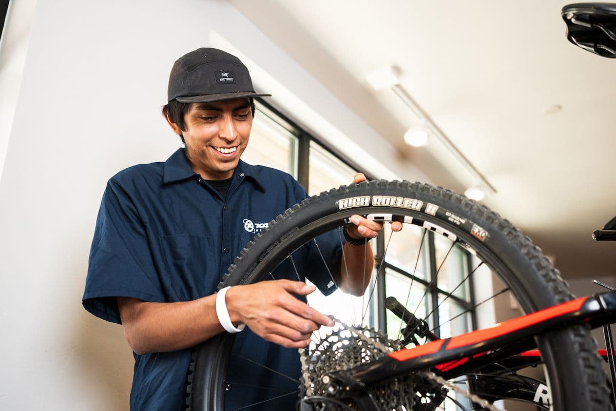 Bike repair technician working on the wheels of a mountain bike in Taos Sports