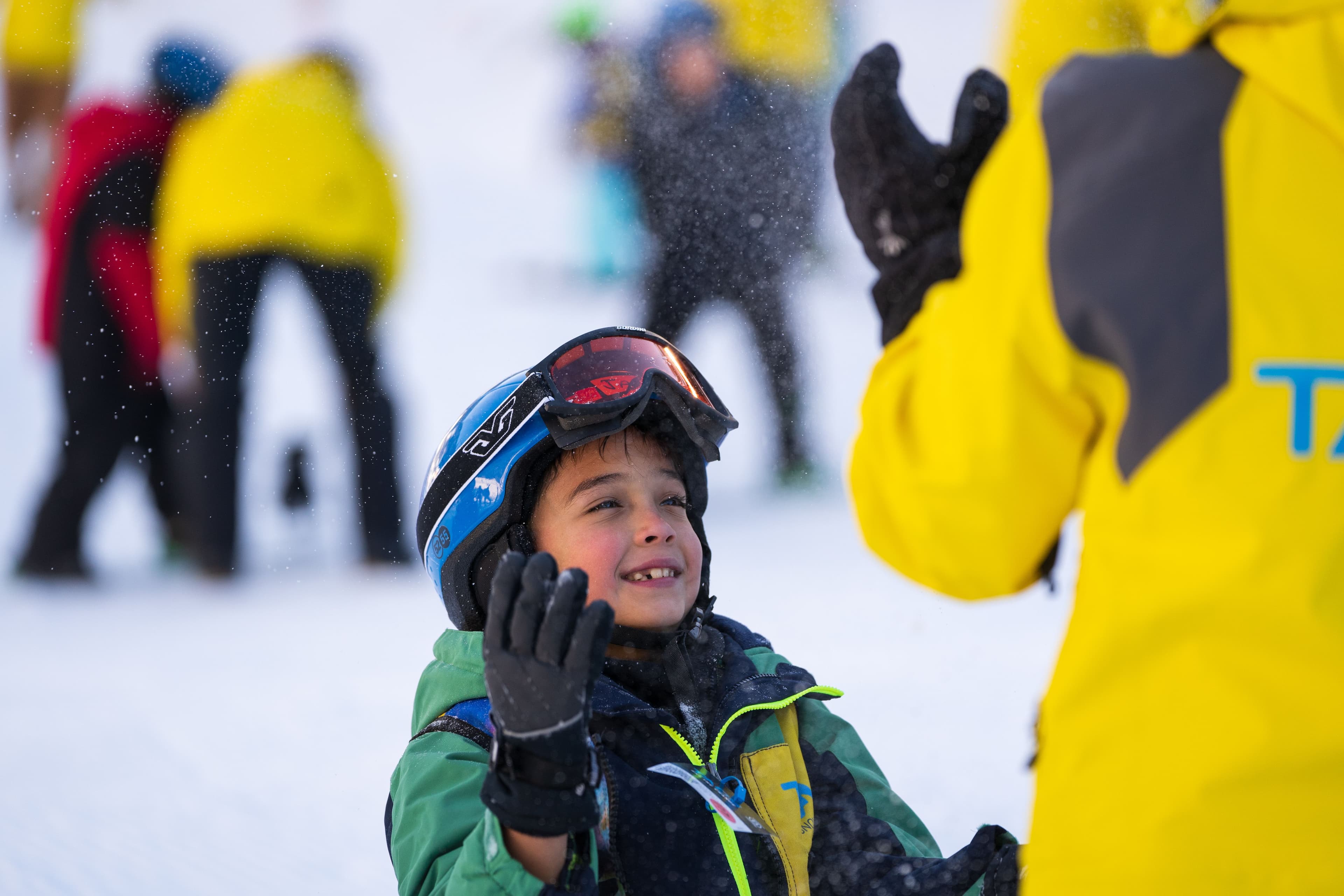 Smiling child talking with an instructor at Taos Ski Valley.