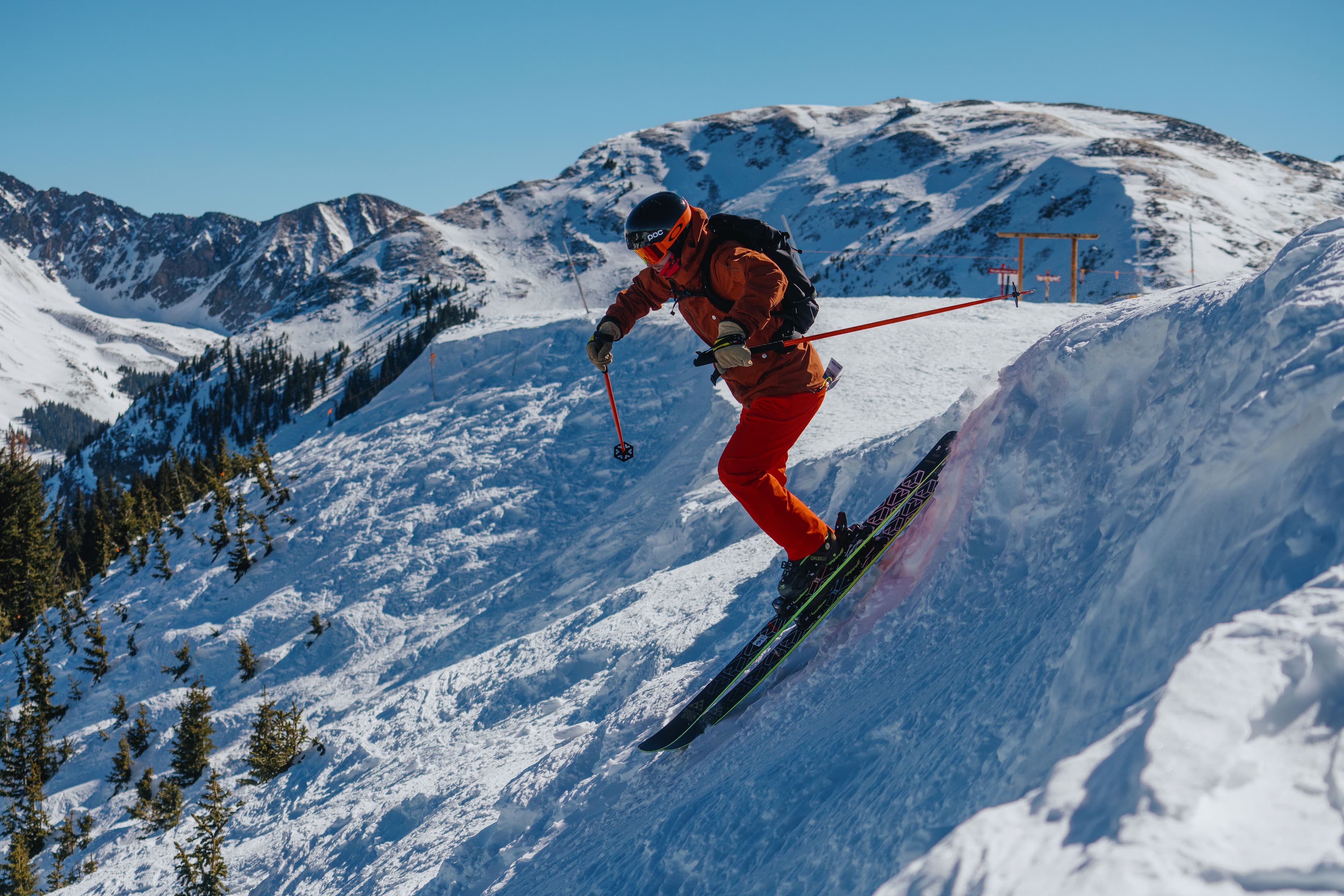 Skier dropping in from a ridge at Taos Ski Valley