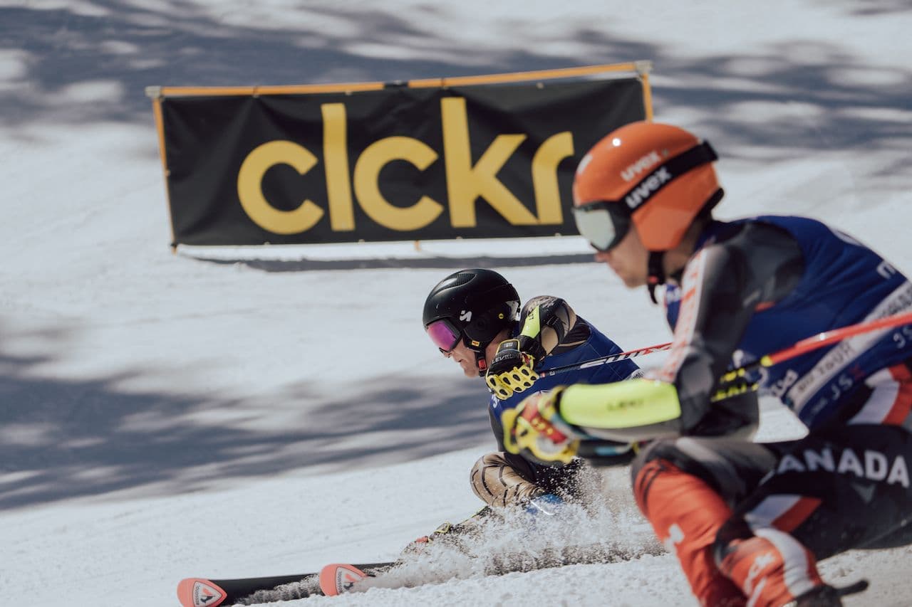Two skiers competing in a downhill skiing race at the World Pro Ski Tour in Taos Ski Valley