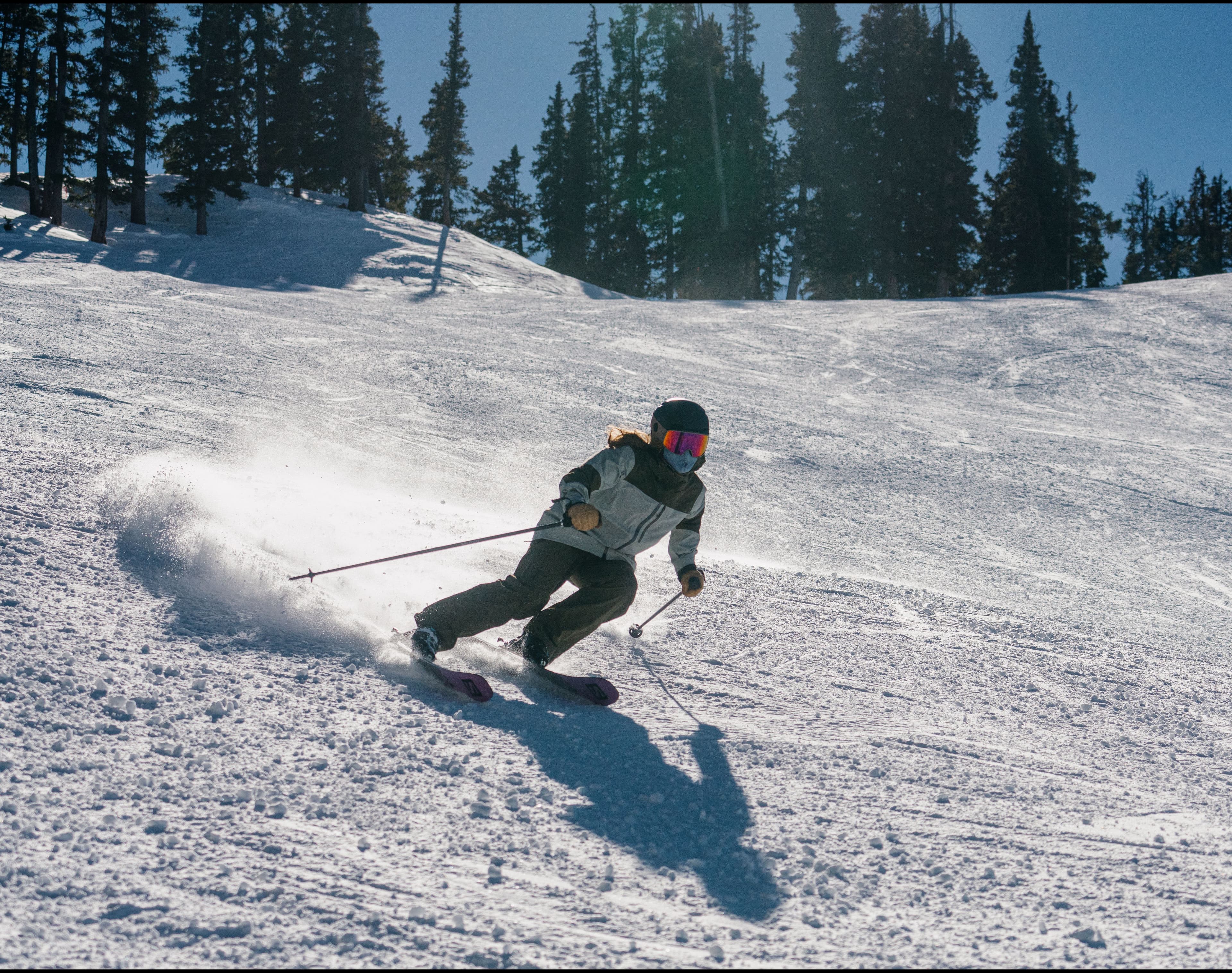 Skier turns downhill on a sunny day 