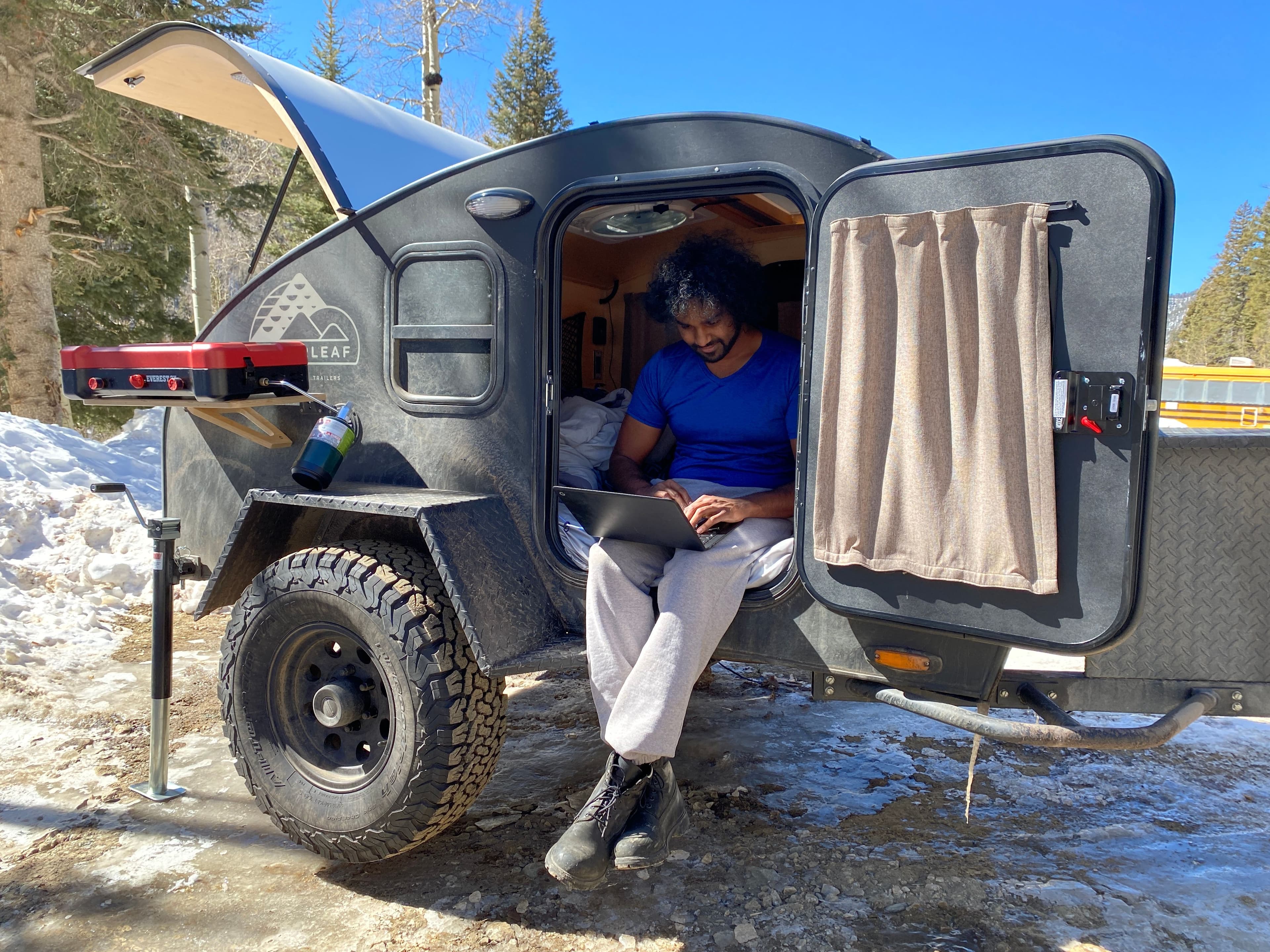 Man relaxing in a Timberleaf trailer parked at Taos Ski Valley.