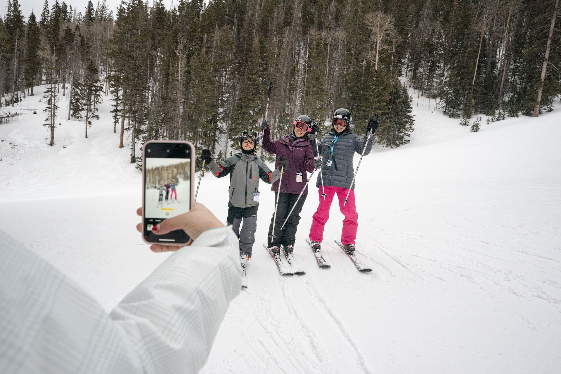Group of teen skiers taking a selfie mid-slope at Taos Ski Valley