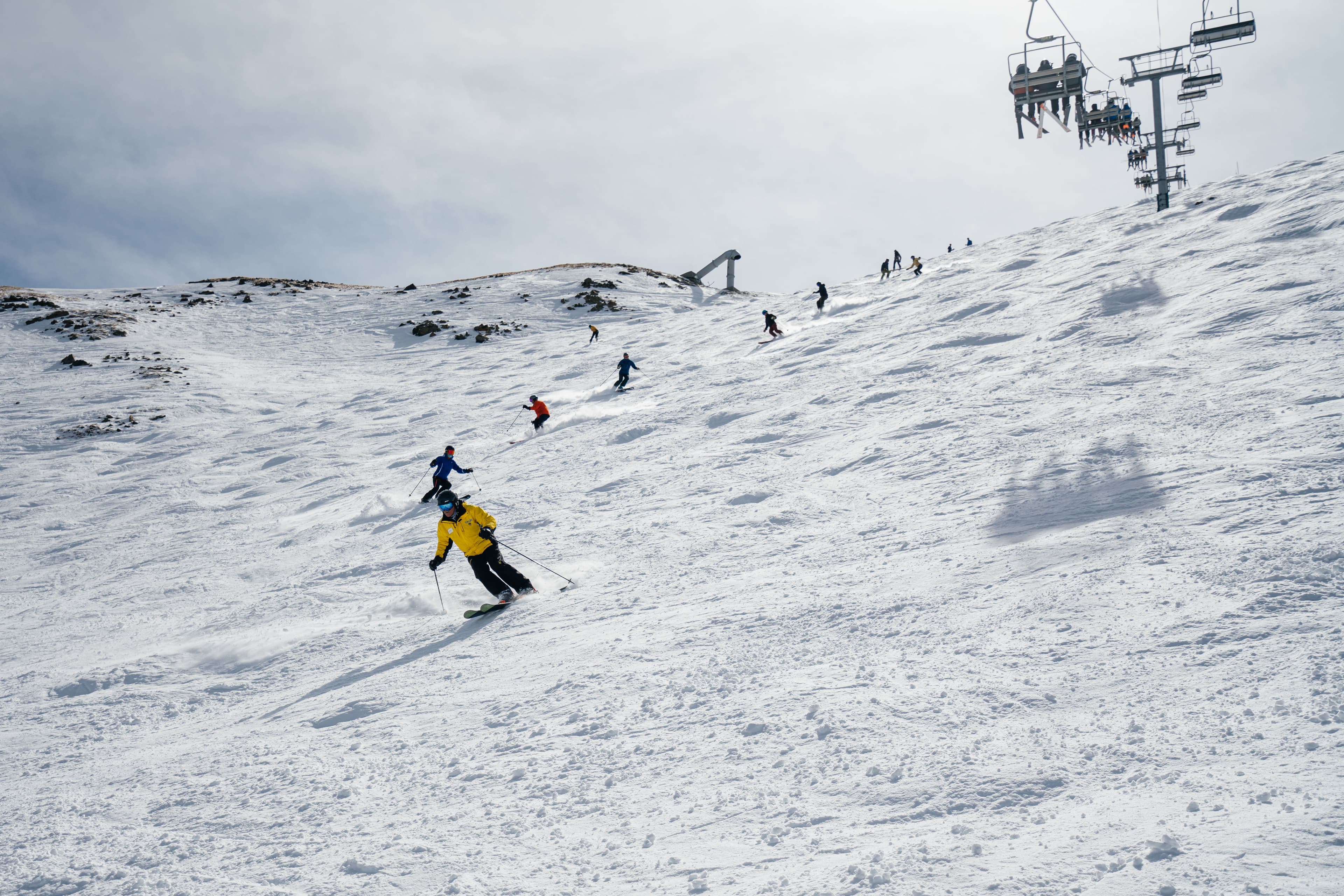 Snowsports instructor leads a group of skiers down kachina peak during a ski week