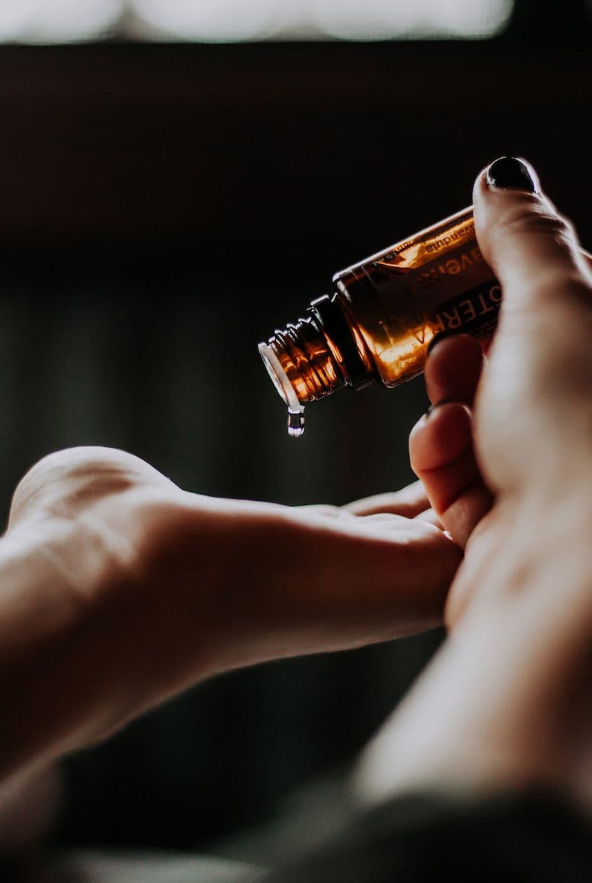 Masseuse pours scalp massage oil onto their hand