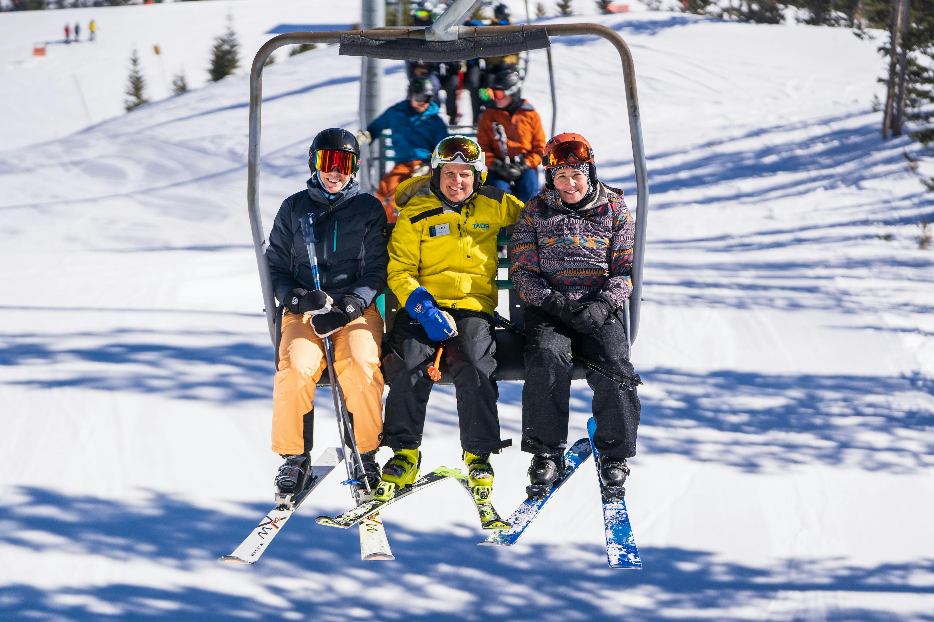 Snowsports instructor shares smiles on the lift with their students