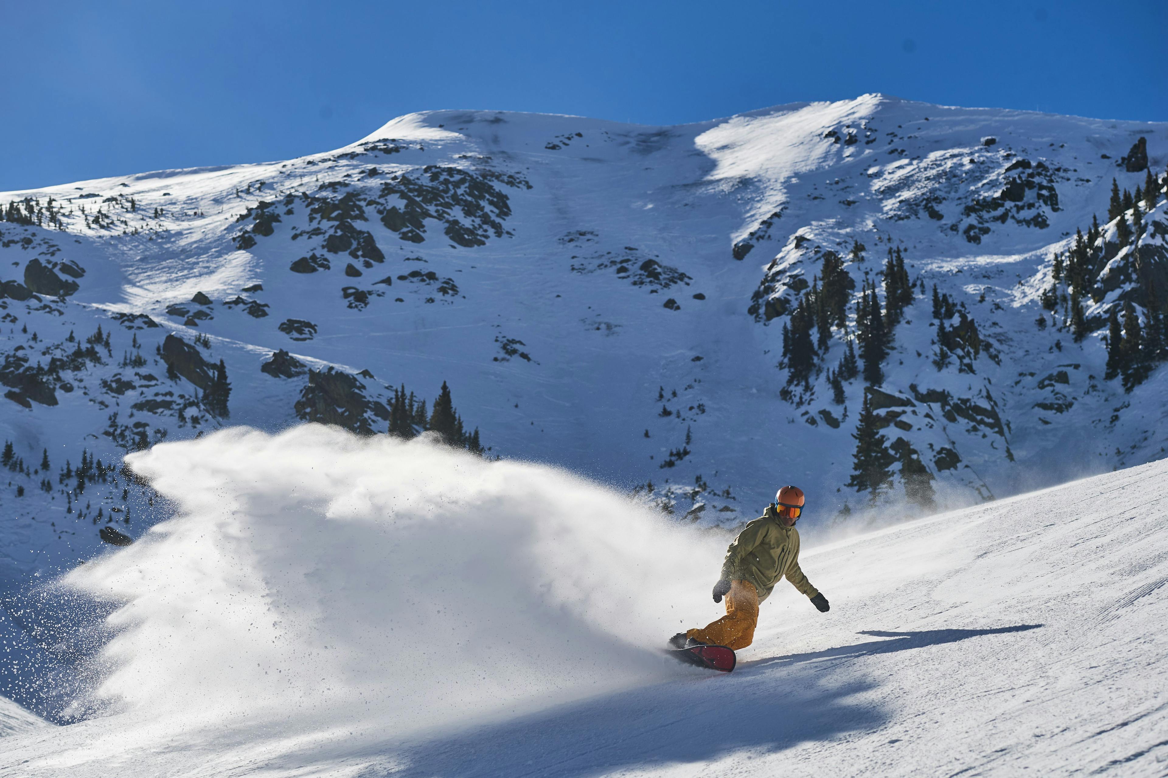 A snowboarder enjoying powder at Taos Ski Valley.
