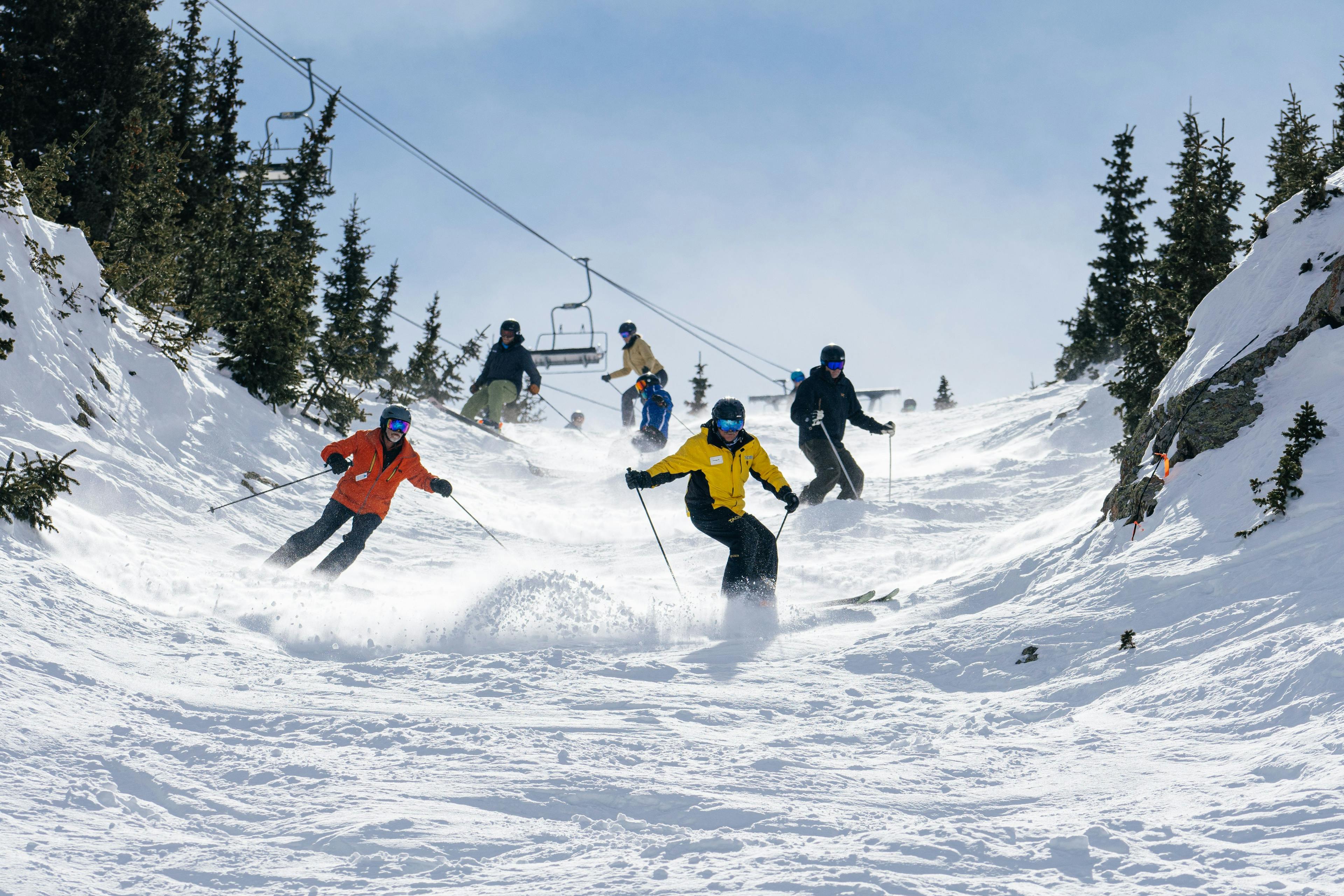 Snowsports instructor leads a group down a chute during a private ski week