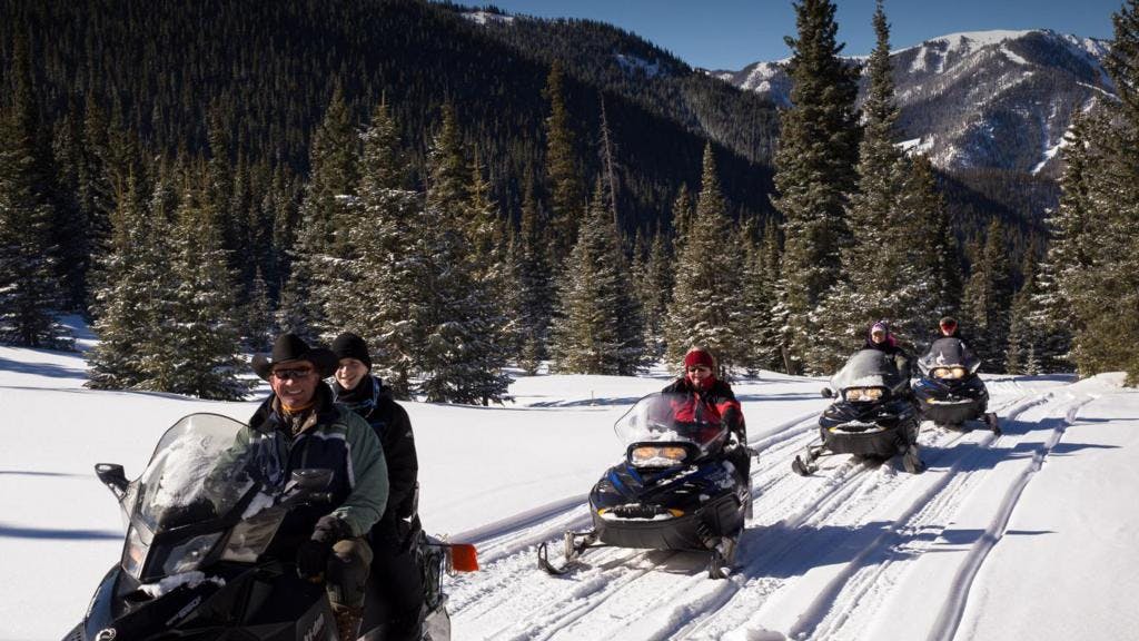 Visitors enjoy a Big Al's snowmobile tour through the snowy mountains